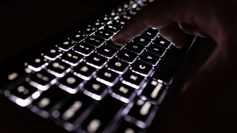 person holding black computer keyboard